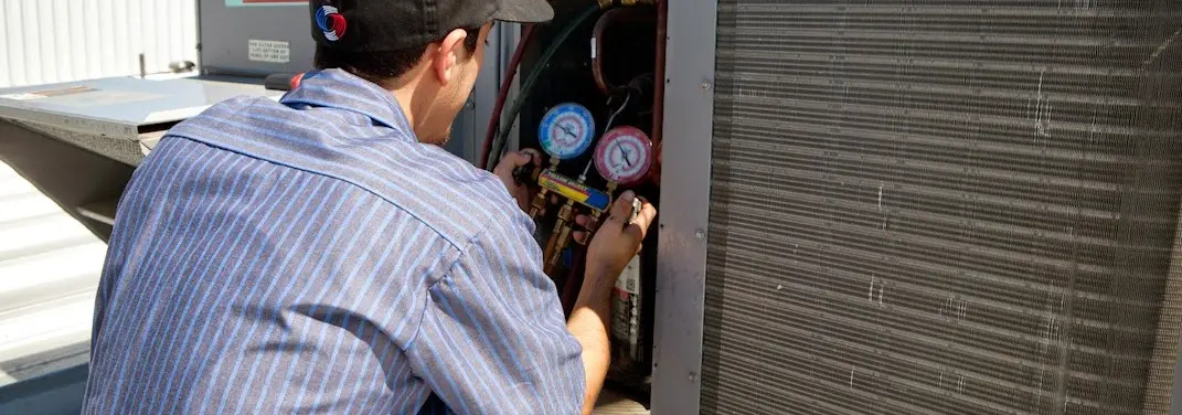 HVAC technician servicing a condenser unit in Radnor
